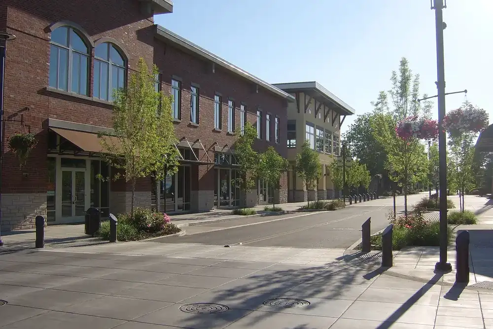 Quiet downtown Washougal sidewalk with brick buildings, street trees and hanging flower baskets